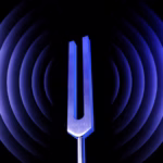 Tuning fork emitting vibrational waves representing sound healing and energetic alignment through frequency therapy