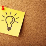 Sticky note with lightbulb icon pinned to cork board representing insight on how often to get massage therapy for health and wellness