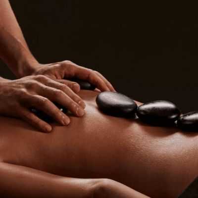 Licensed massage therapist performing deep tissue massage with hot stones in Olympia WA